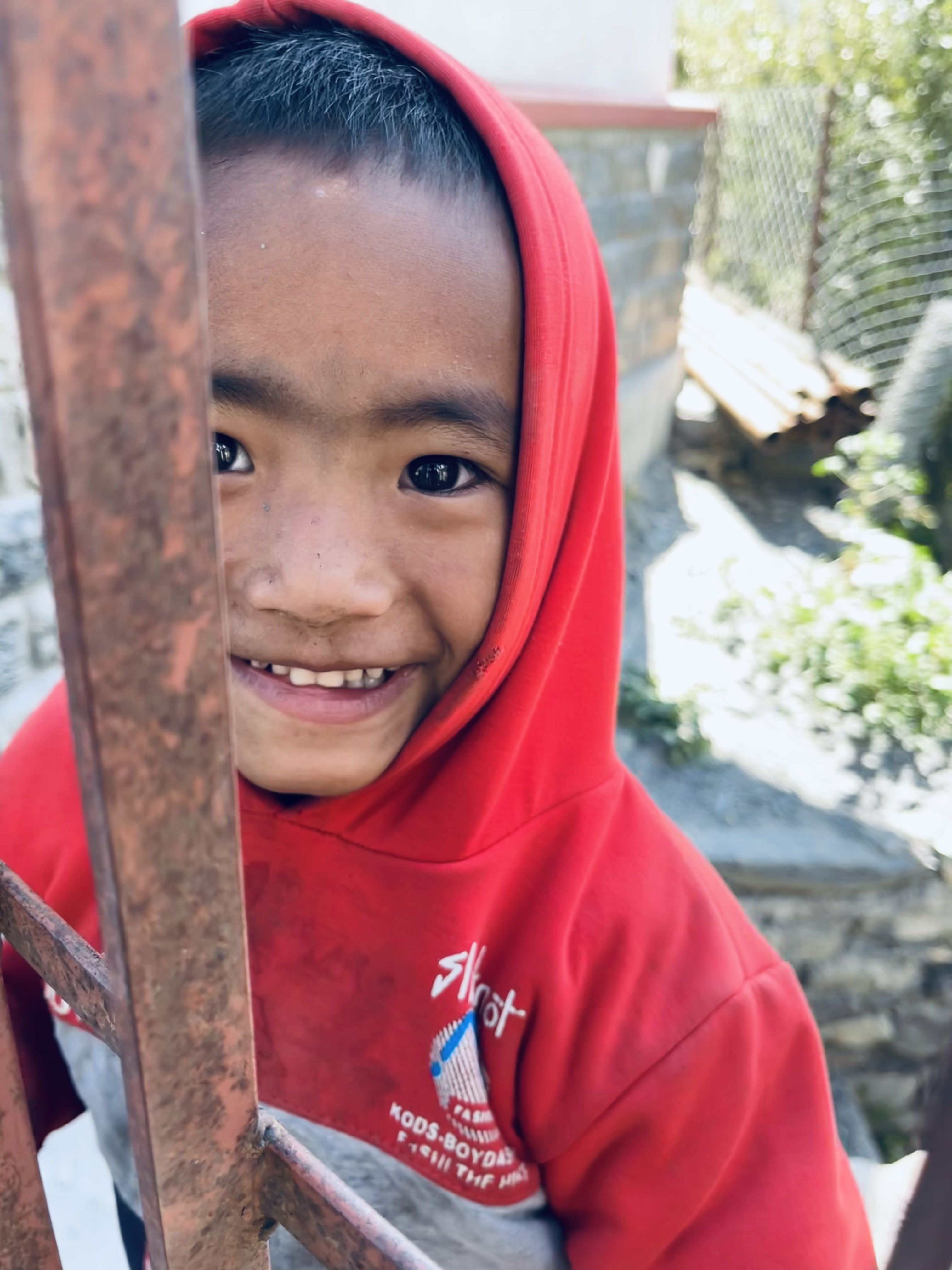 Through Mustang's gate, a boy in red